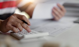 Close up of hand using calculator